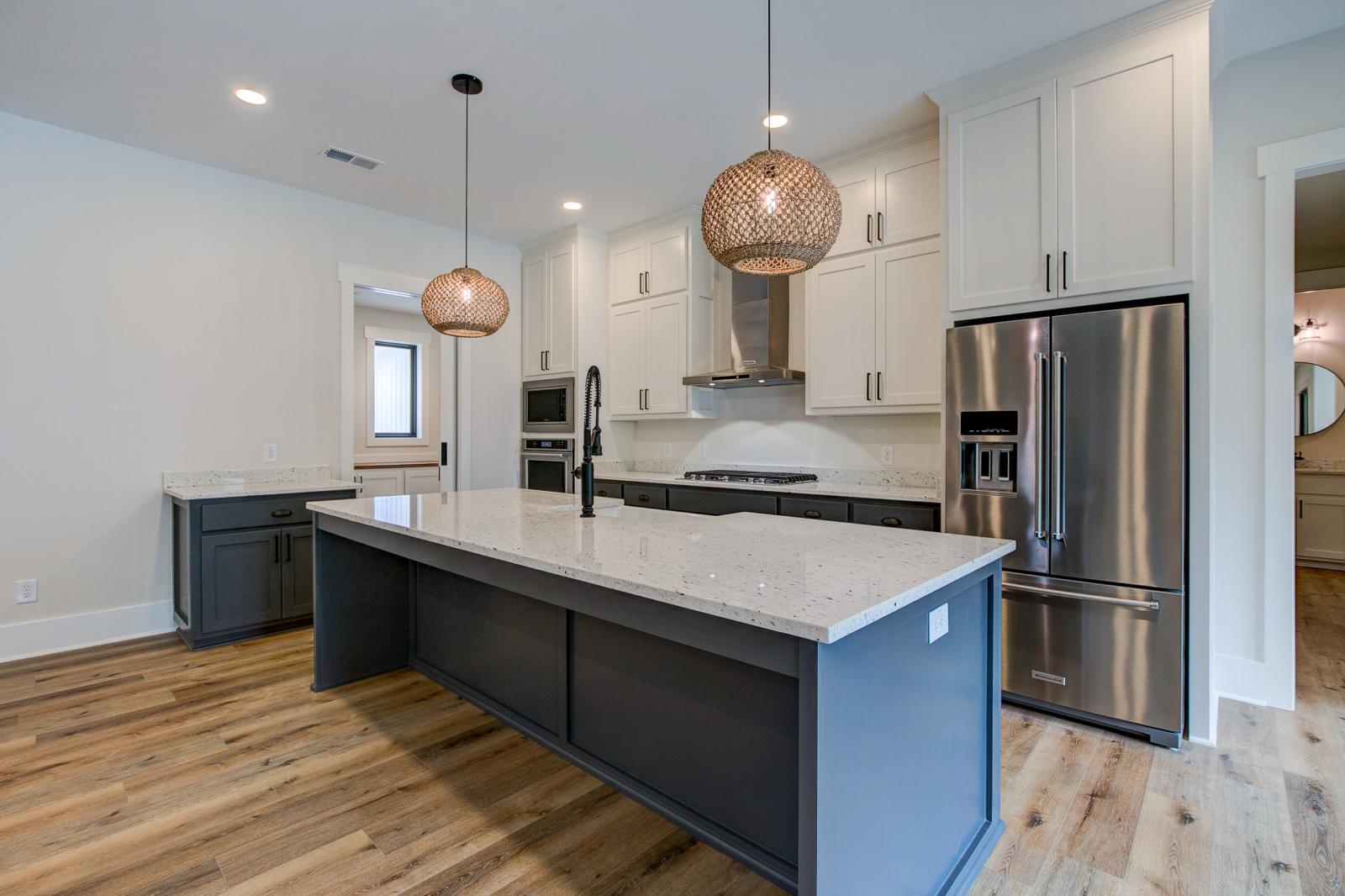 Open concept kitchen with white cabinets and large island - Rafter B Construction custom home