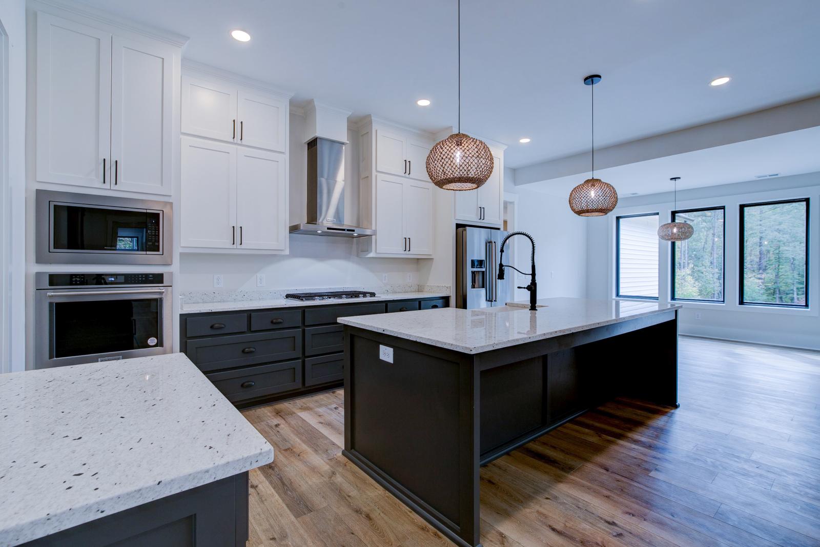 Open concept kitchen with white cabinets and large island - Rafter B Construction custom home