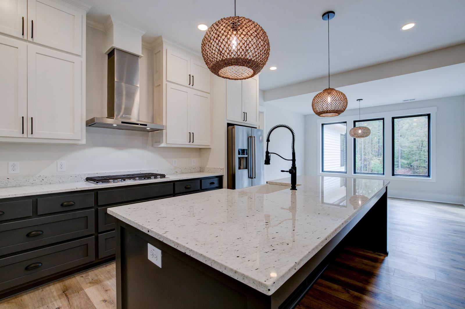 Open concept kitchen with white cabinets and large island - Rafter B Construction custom home