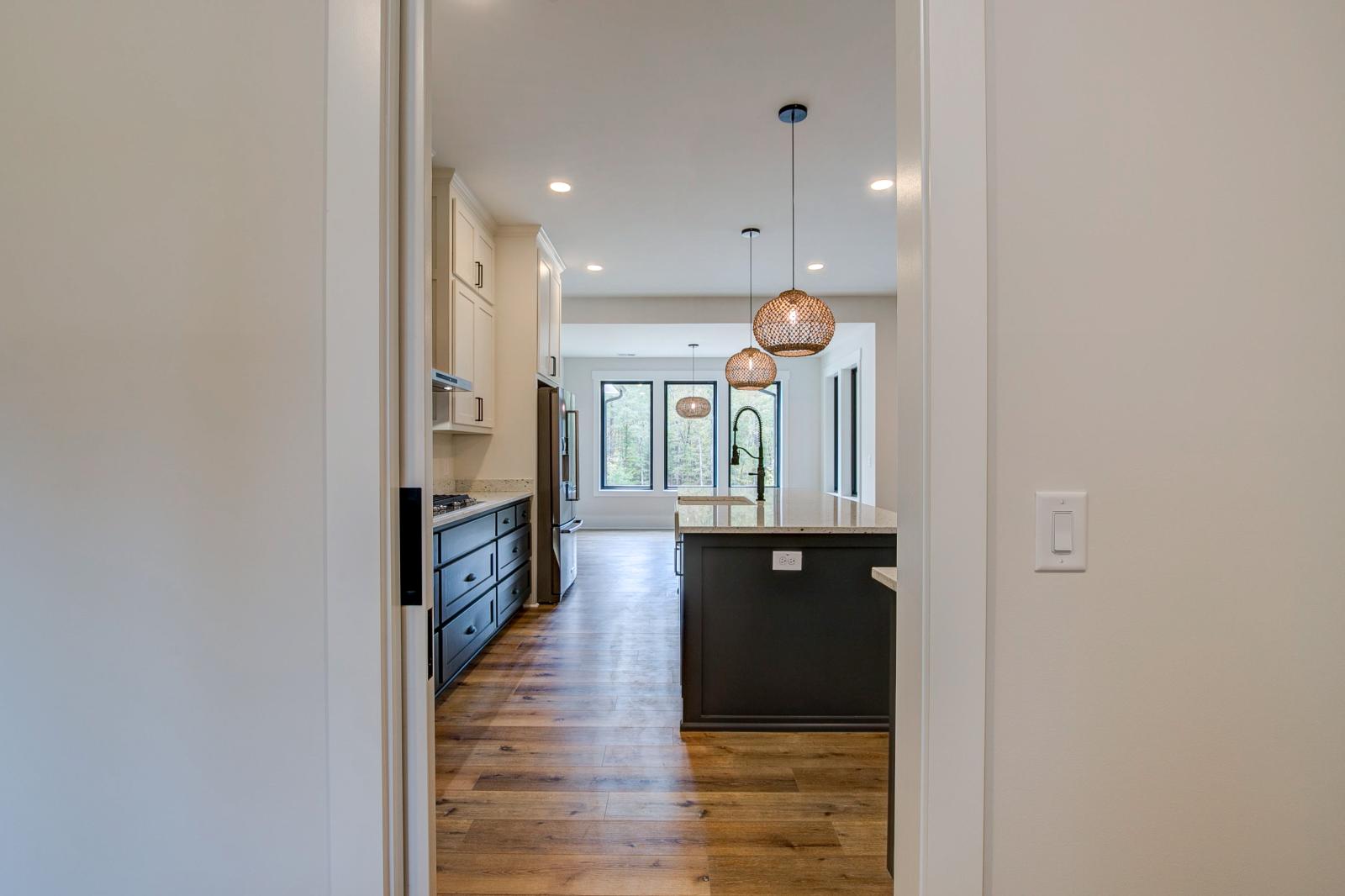 Open concept kitchen with white cabinets and large island - Rafter B Construction custom home