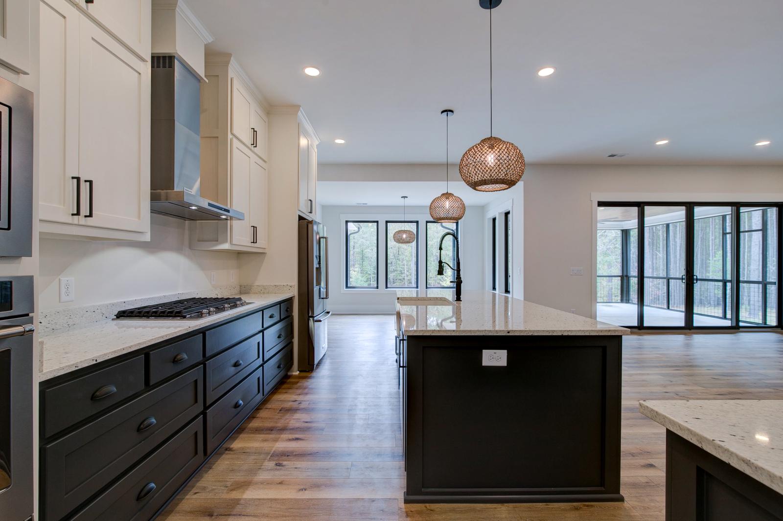 Open concept kitchen with white cabinets and large island - Rafter B Construction custom home