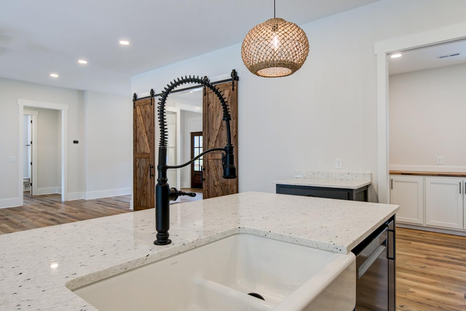 Open concept kitchen with white cabinets and large island - Rafter B Construction custom home