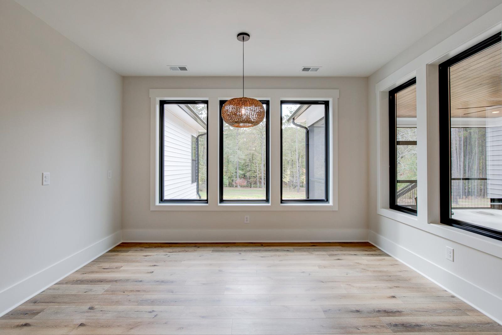 Dining room with wood floors, white walls and large windows