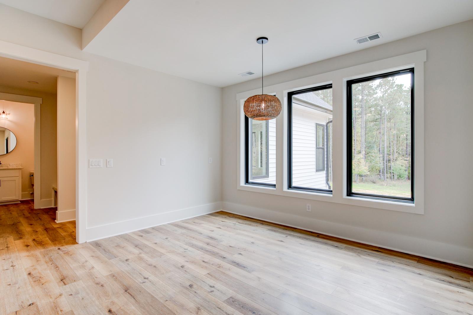 Dining room with wood floors, white walls and large windows