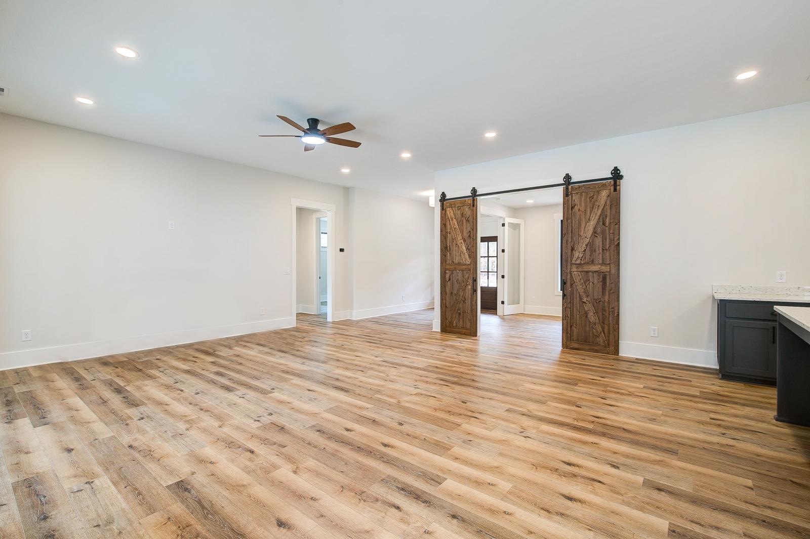Room with wood floors, white walls and large windows