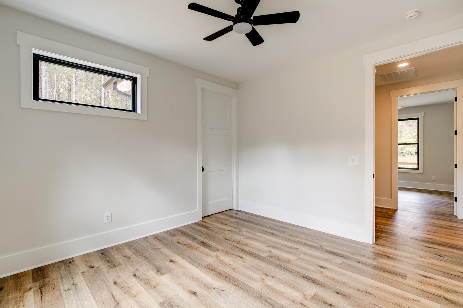 Room with wood floors, white walls and ceiling fan