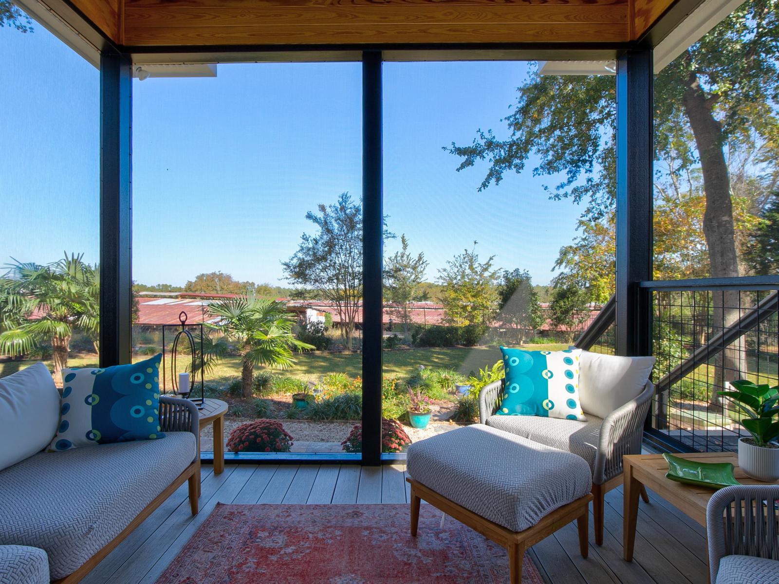 View of the inside of a screened back porch facing the backyard.