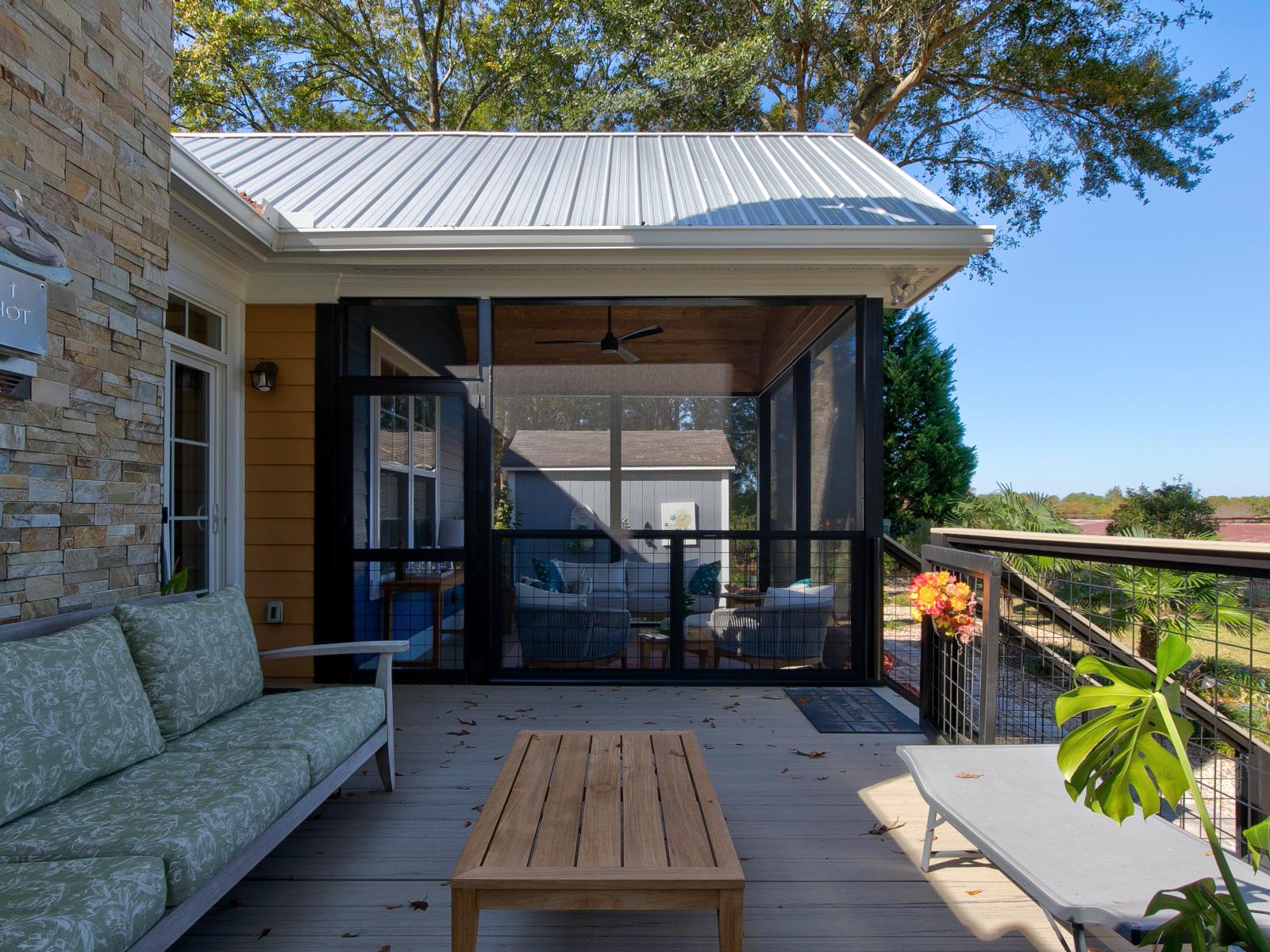 View of screened section of a screened back porch from the unscreened section of the back porch.